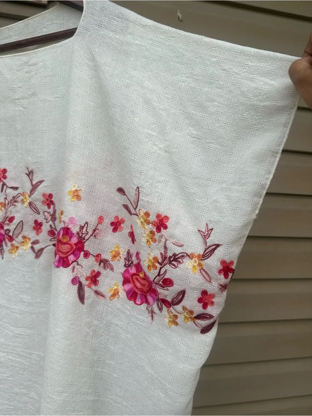 Soft cream cotton-mul feel poncho with vibrant pink, red floral embroidery.
